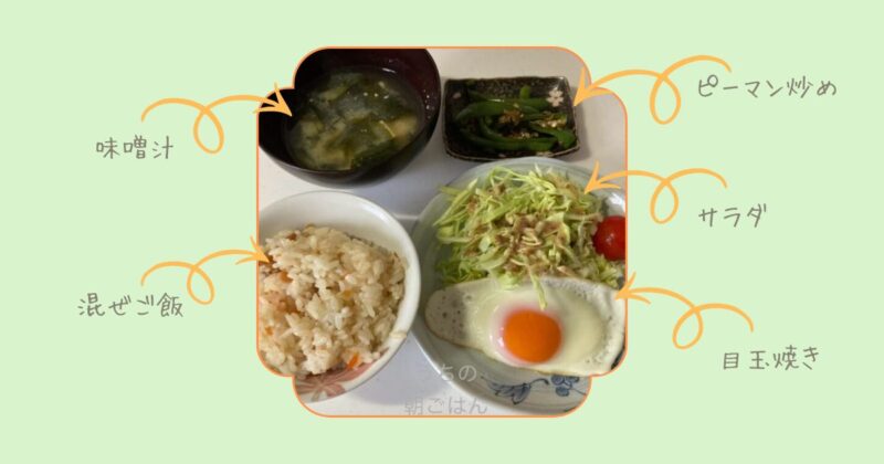 朝食の食卓写真。混ぜご飯、味噌汁、目玉焼き、サラダ、ピーマン炒めが並んでいる