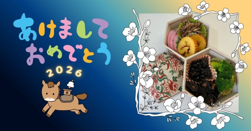 新年の挨拶「あけましておめでとう」と、ミニおせち、干支の飾りが写った写真